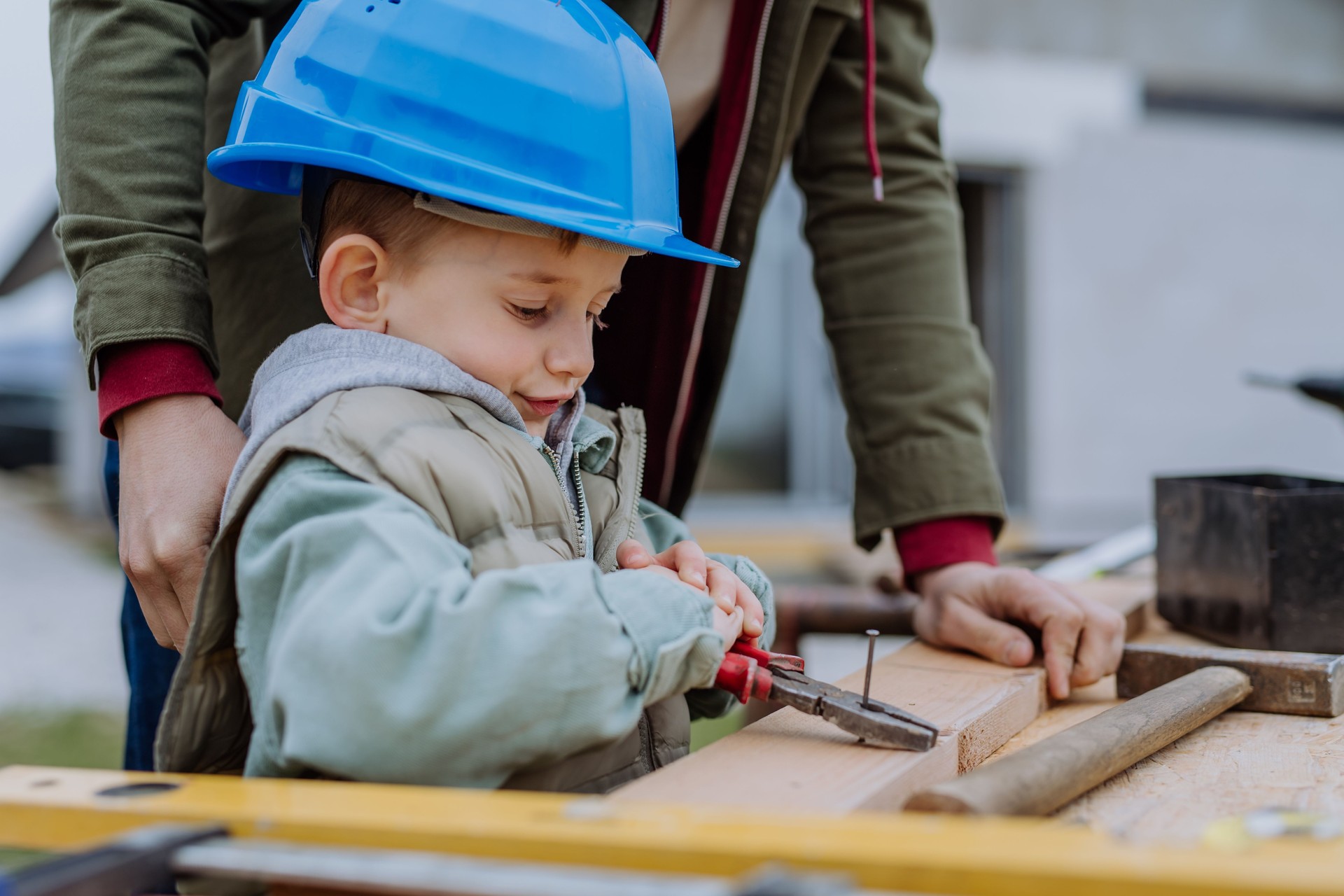 Père et son petit fils travaillant devant leur maison inachevée.